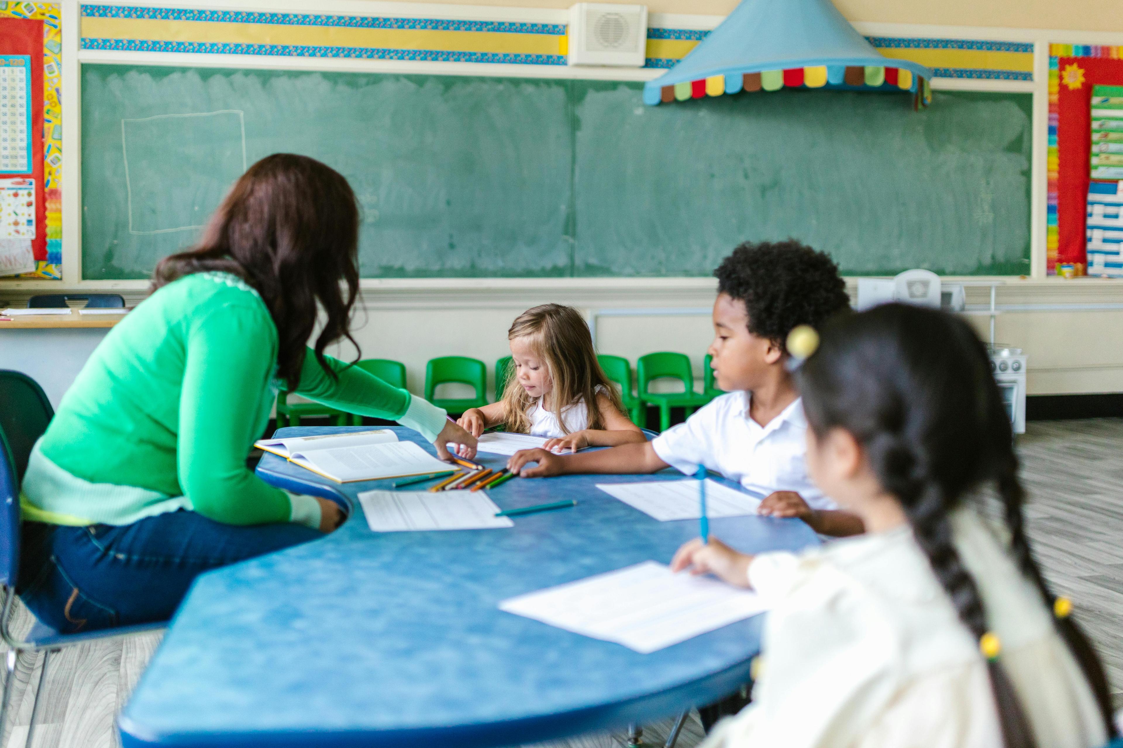 Young children gathered around a classroom table during a guided daycare learning activity.